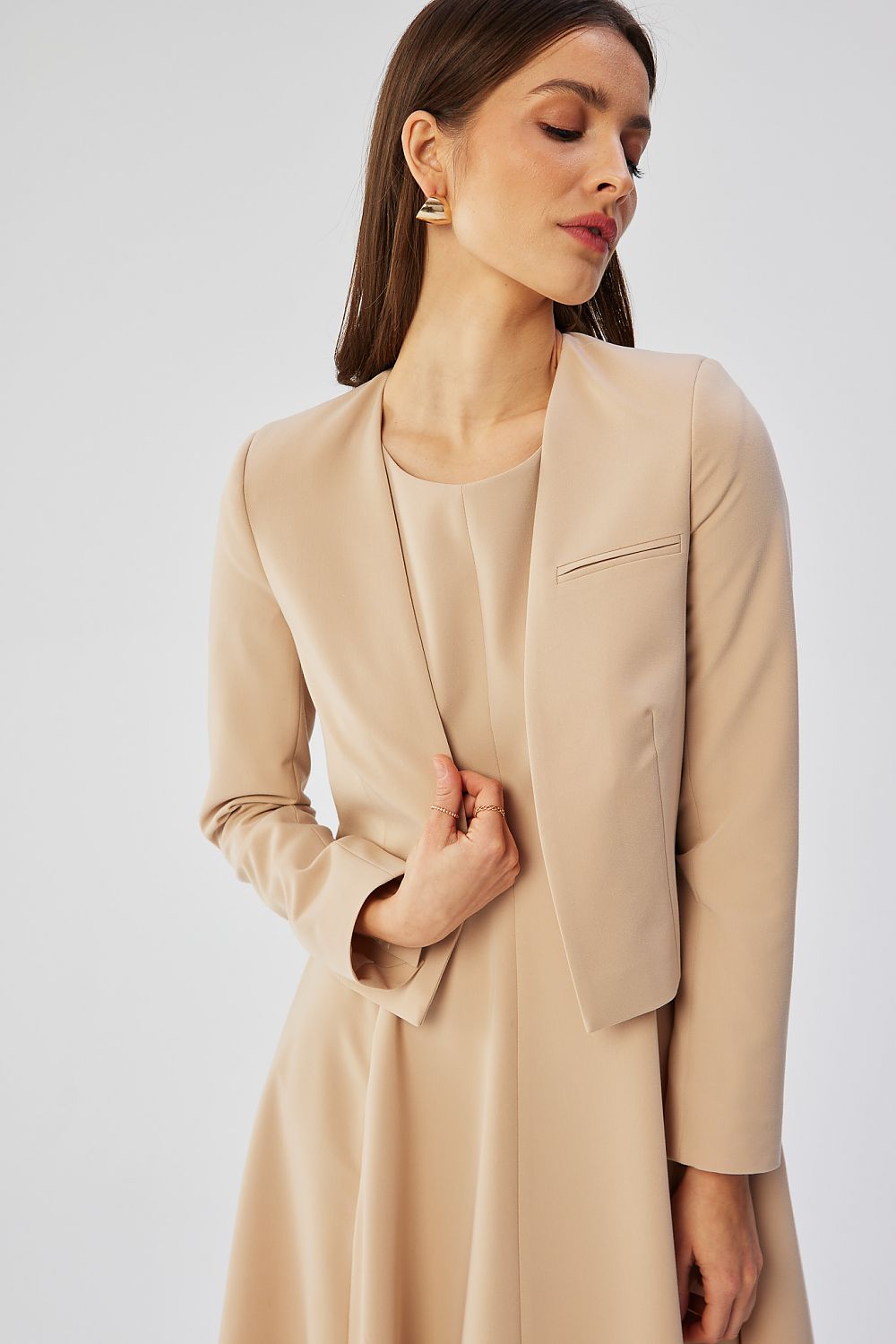 Veste courte beige VidenaParis, style élégant et décontracté, portée avec une robe fluide pour un look moderne.