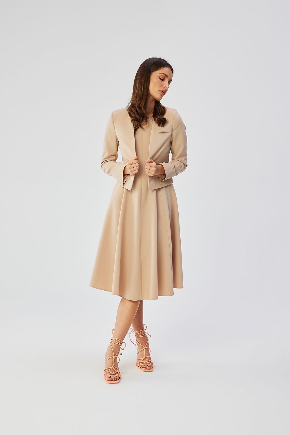 Veste courte beige VidenaParis, style élégant et décontracté, portée avec une robe fluide pour un look moderne.
