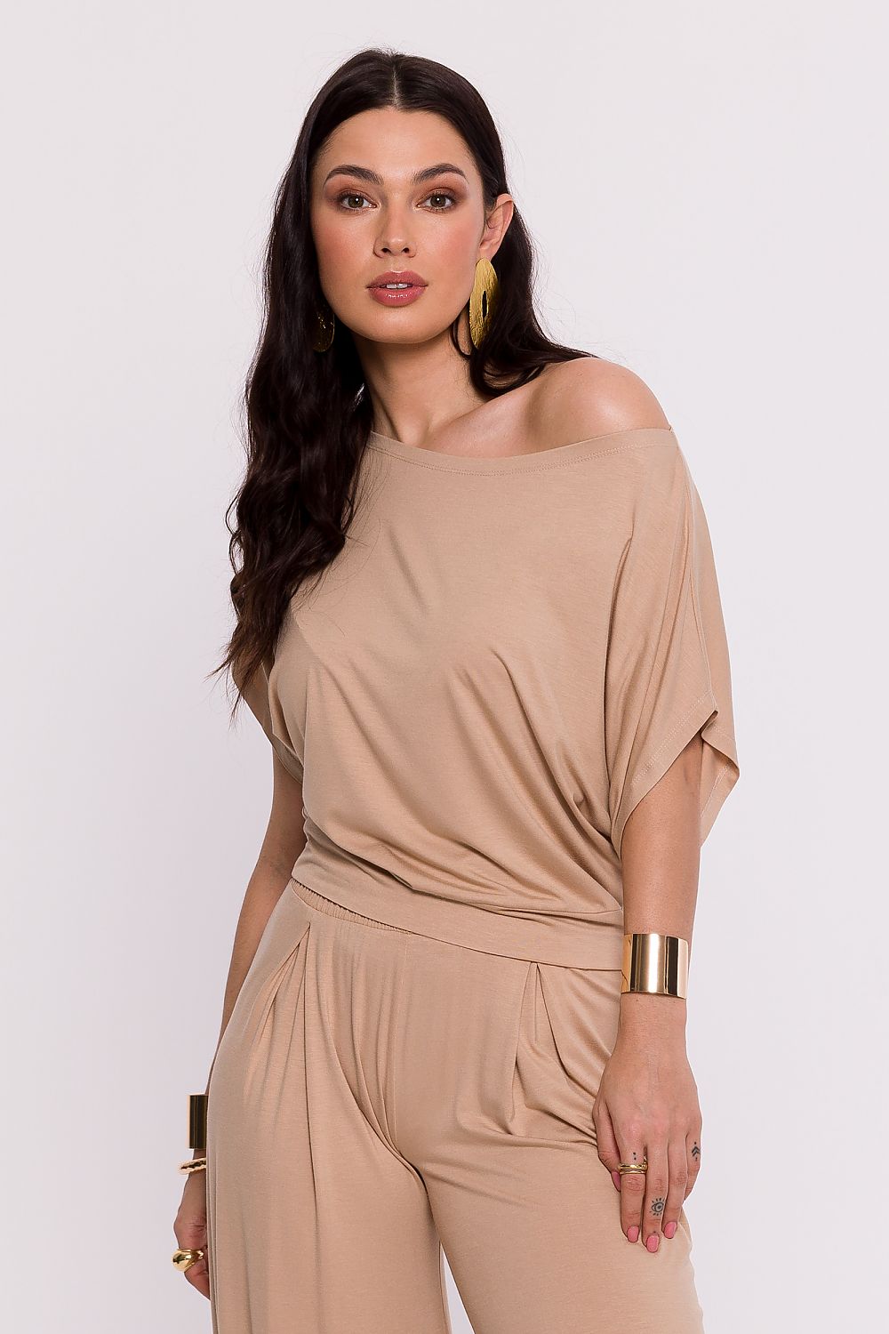 Femme portant une chemise beige fluide fabriquée en Europe, mode parisienne