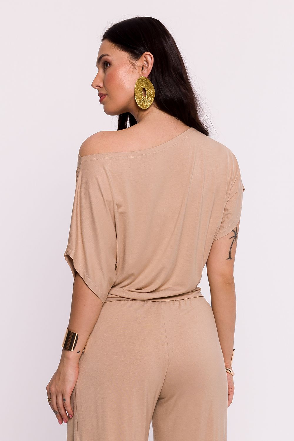 Femme portant une chemise beige fluide fabriquée en Europe, mode parisienne
