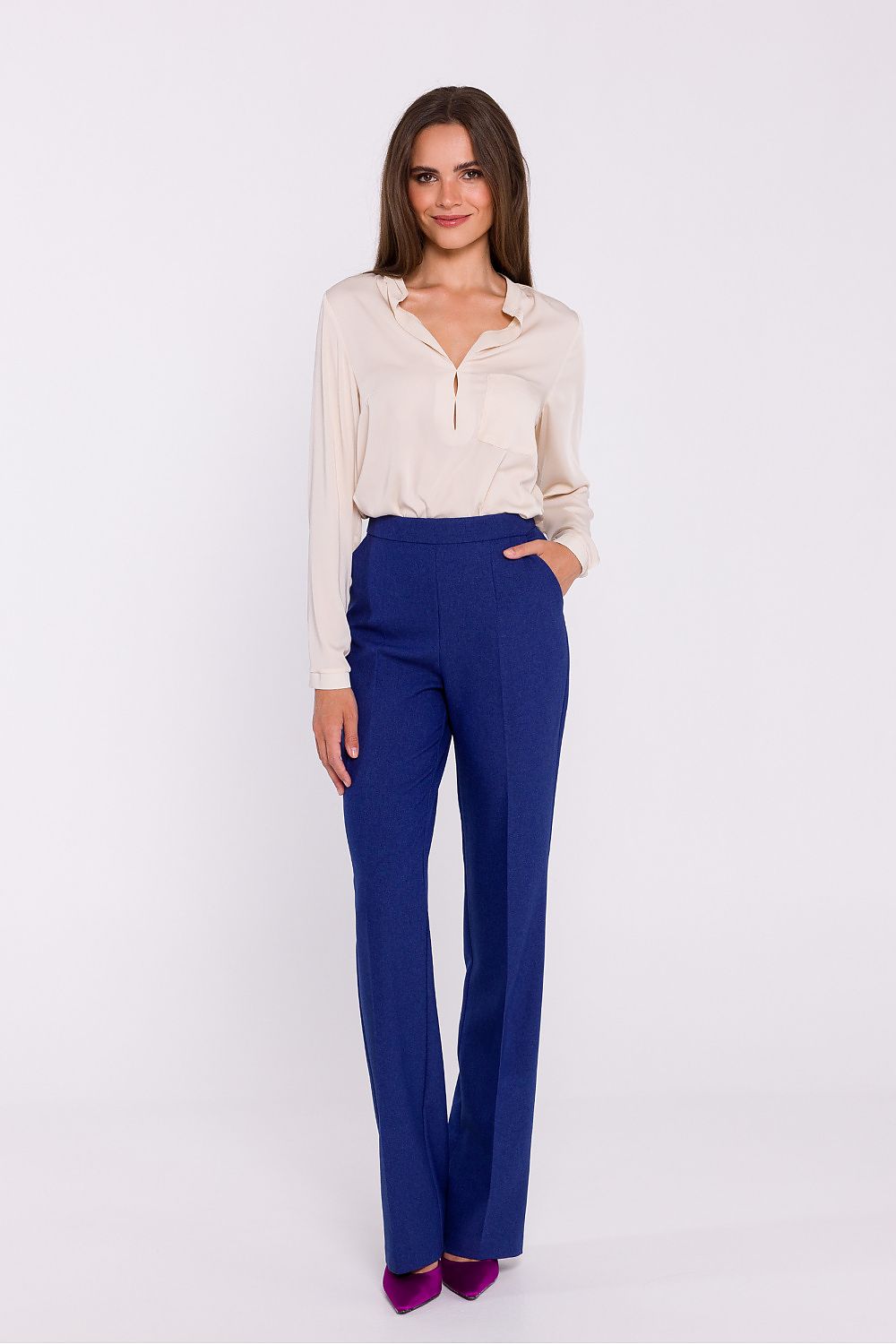 Femme portant une blouse satinée beige à col montant, manches longues et poche poitrine, fabriquée en Europe, mode parisienne