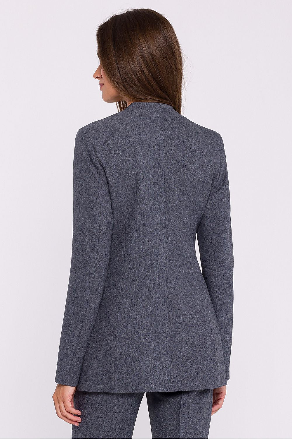 Femme portant un blazer élégant couleur gris avec fleur décorative, fabriqué en Europe, inspiré par la mode parisienne