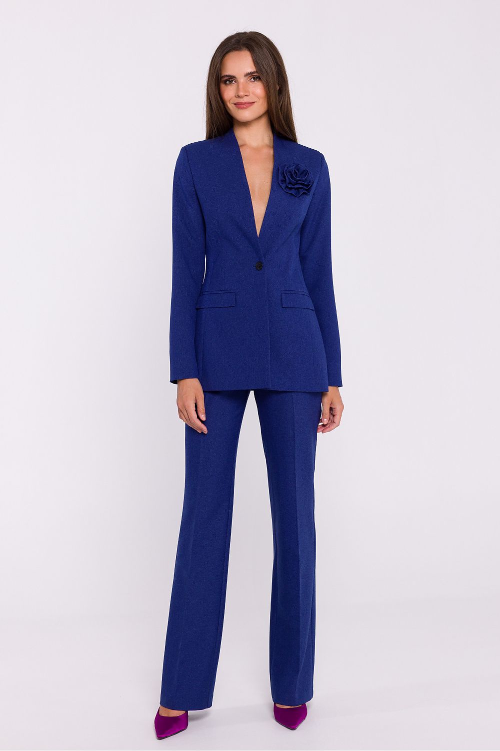 Femme portant un blazer élégant couleur bleu avec fleur décorative, fabriqué en Europe, inspiré par la mode parisienne