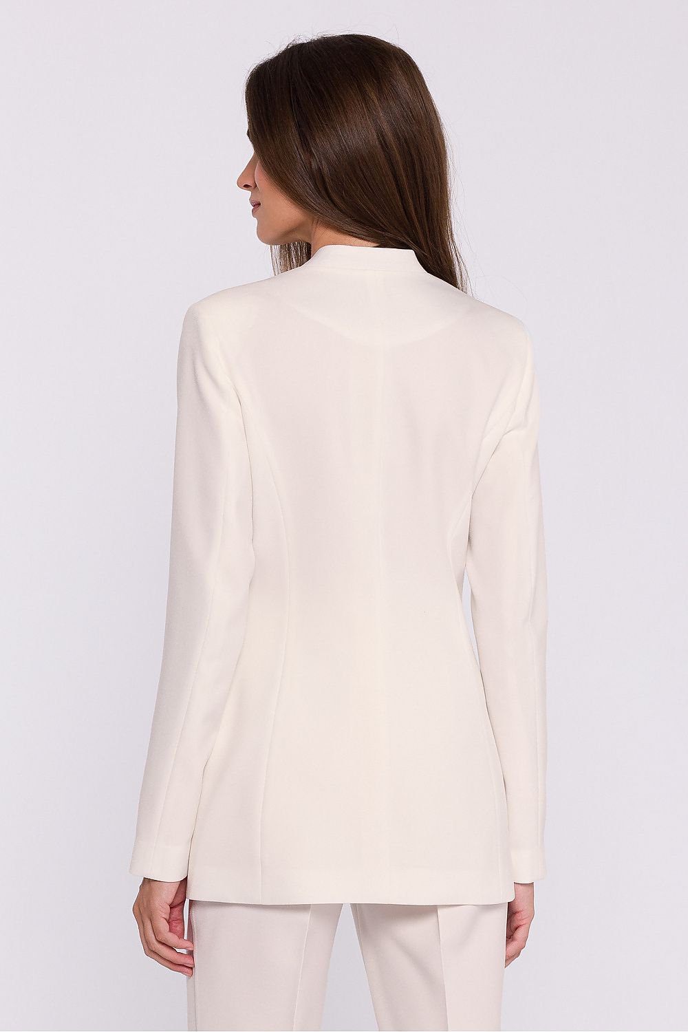 Femme portant un blazer élégant couleur blanc avec fleur décorative, fabriqué en Europe, inspiré par la mode parisienne