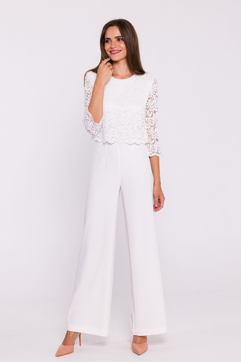 Femme portant une combinaison blanc avec haut en dentelle et pantalon large, fabriquée en Europe, mode parisienne
