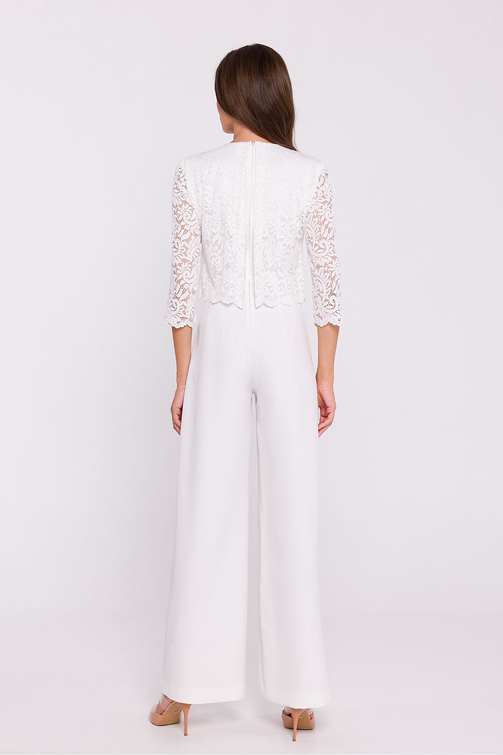 Femme portant une combinaison blanc avec haut en dentelle et pantalon large, fabriquée en Europe, mode parisienne