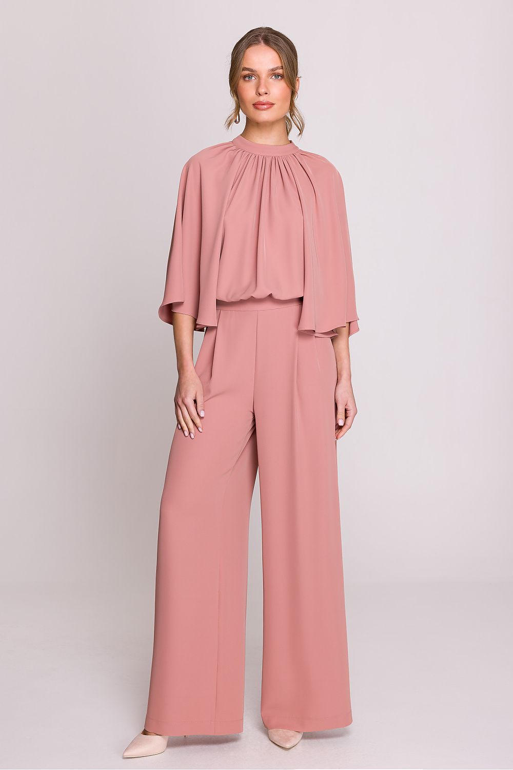 Femme portant un ensemble fluide rose poudré à manches chauve-souris, pantalon large taille haute, fabriqué en Europe, mode parisienne élégante