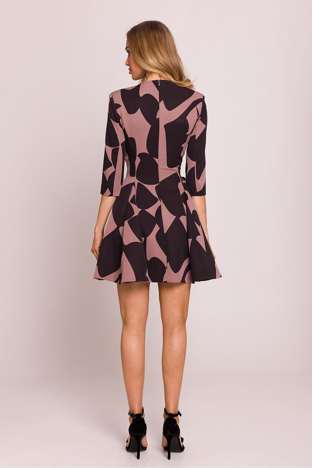 Femme portant une robe courte imprimée noire et rose avec décolleté en V, boutons décoratifs à la taille et jupe évasée plissée, conçue en Europe, mode parisienne chic et féminine