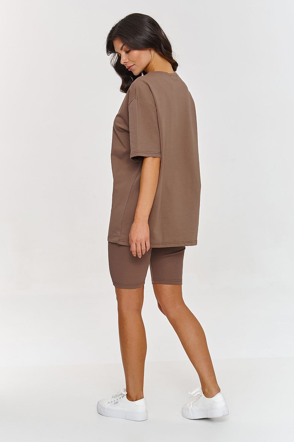 Femme portant un ensemble brun avec t-shirt oversize et short legging moulant, mode parisienne, fabriqué en Europe