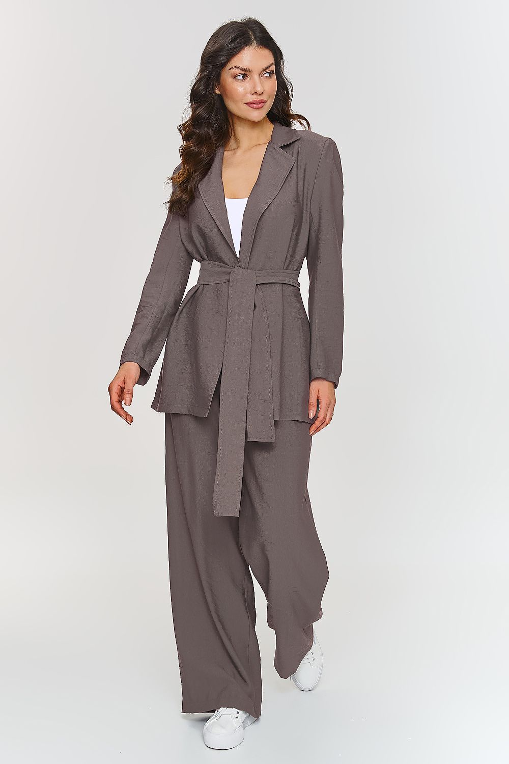 Femme portant un ensemble brun élégant avec blazer ceinturé et pantalon large, fabriqué en Europe, mode parisienne