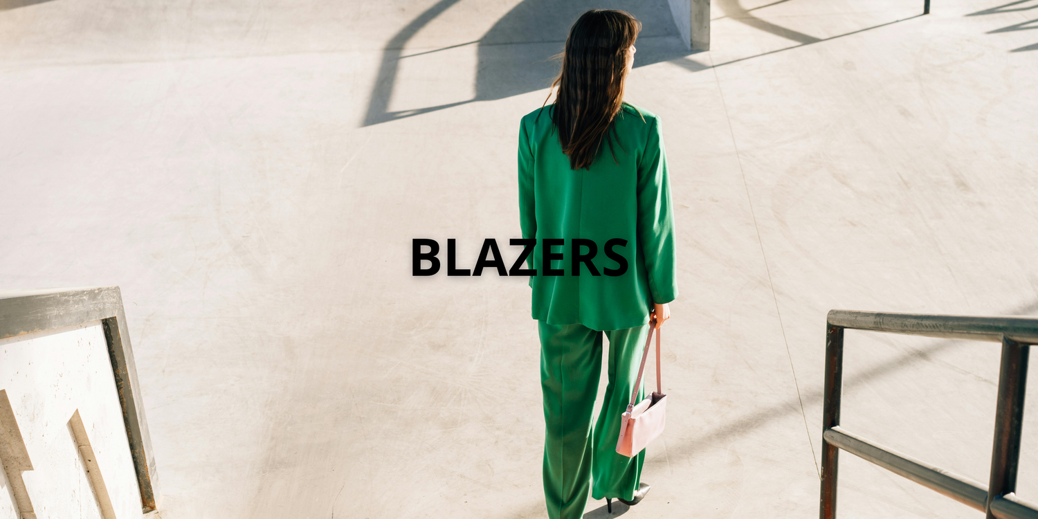 Trois femmes élégantes portant des blazers fabriqués en Europe — blanc, noir et orange — sous un ciel bleu clair, représentant la collection VidenaParis.