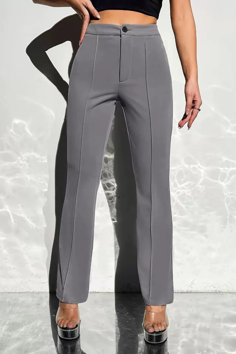 Pantalon gris taille haute à pinces pour femme, coupe droite élégante avec fermeture zippée et détails de couture sur le devant.