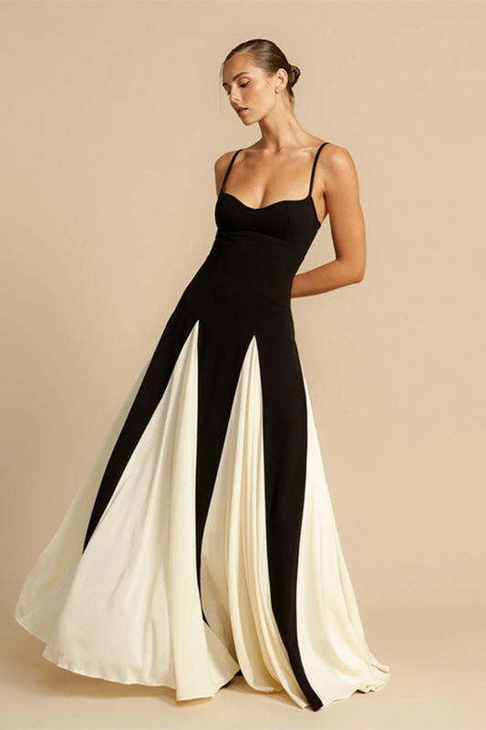 Robe longue noire et blanche à bretelles fines, bustier ajusté et jupe fluide évasée avec panneaux contrastés en blanc.