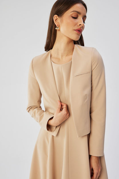 Veste courte beige VidenaParis, style élégant et décontracté, portée avec une robe fluide pour un look moderne.