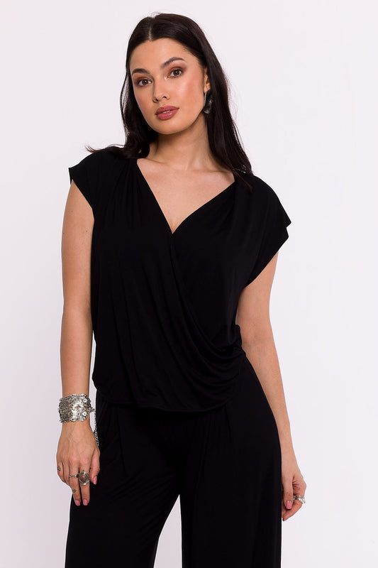 Femme portant une chemise noire croisée élégante fabriquée en Europe, mode parisienne