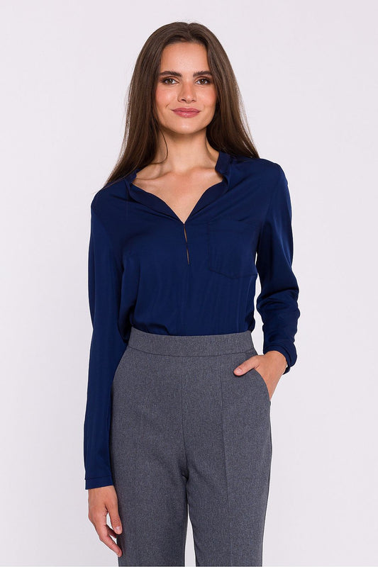Femme portant une blouse satinée bleu marine à col montant, manches longues et poche poitrine, fabriquée en Europe, mode parisienne