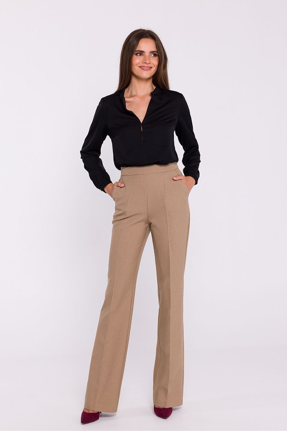 Femme portant une blouse satinée noir à col montant, manches longues et poche poitrine, fabriquée en Europe, mode parisienne