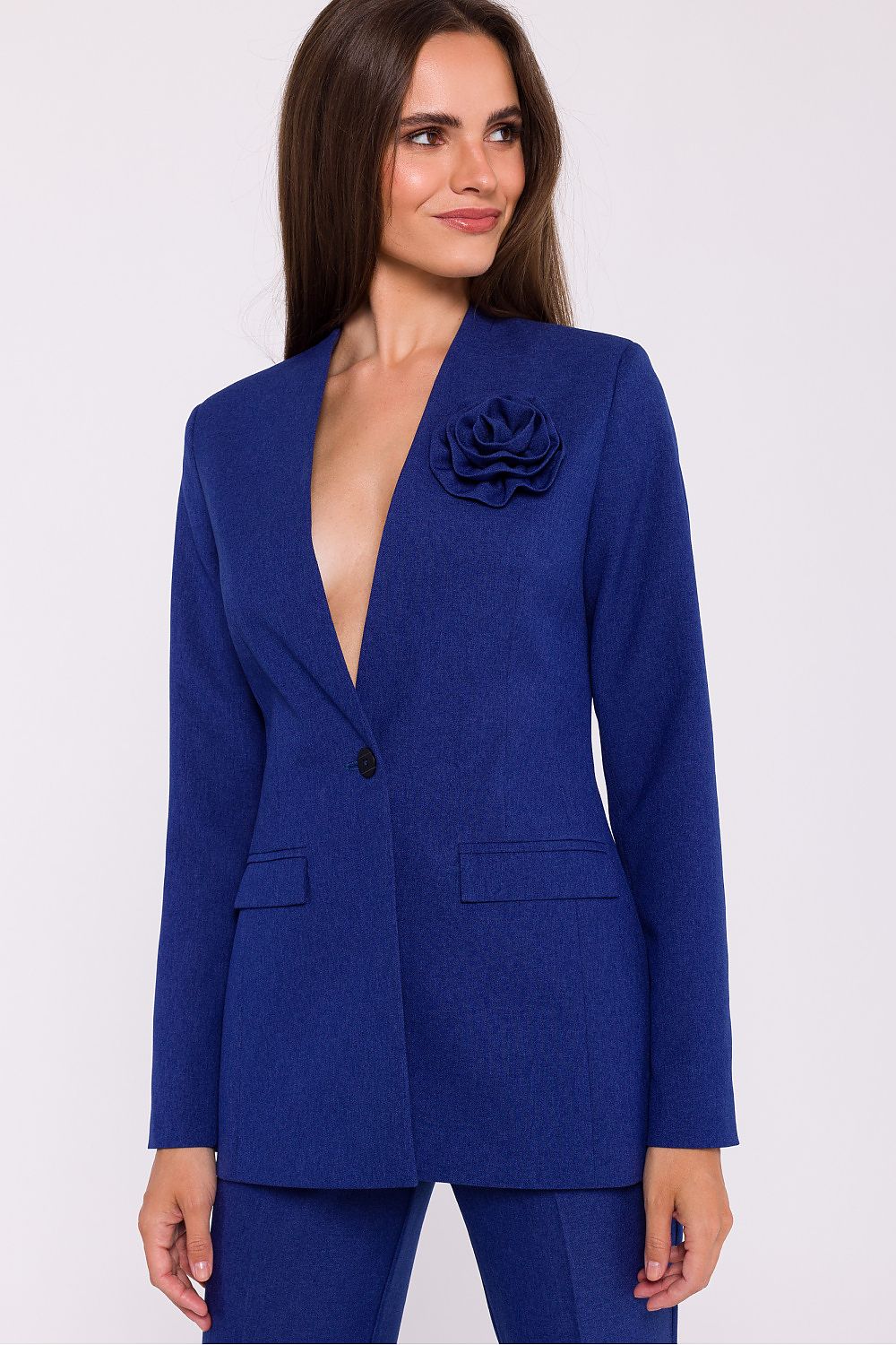 Femme portant un blazer élégant couleur bleu avec fleur décorative, fabriqué en Europe, inspiré par la mode parisienne