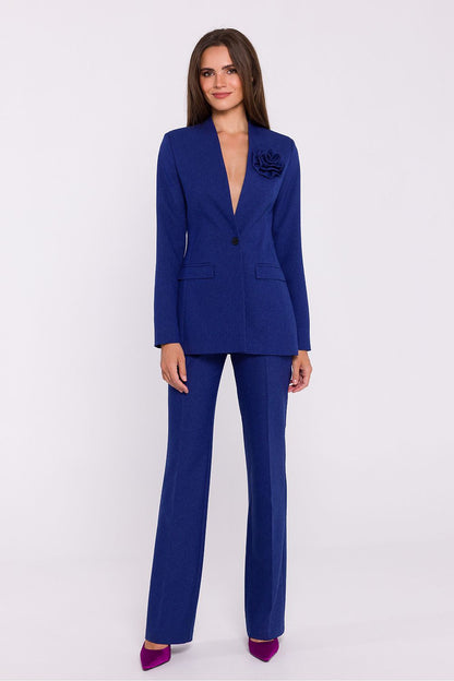 Femme portant un blazer élégant couleur bleu avec fleur décorative, fabriqué en Europe, inspiré par la mode parisienne