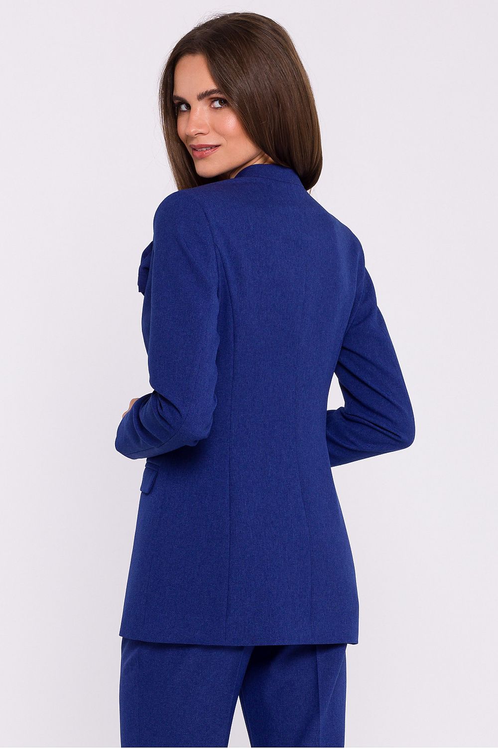 Femme portant un blazer élégant couleur bleu avec fleur décorative, fabriqué en Europe, inspiré par la mode parisienne