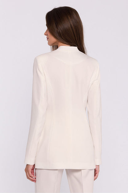 Femme portant un blazer élégant couleur blanc avec fleur décorative, fabriqué en Europe, inspiré par la mode parisienne