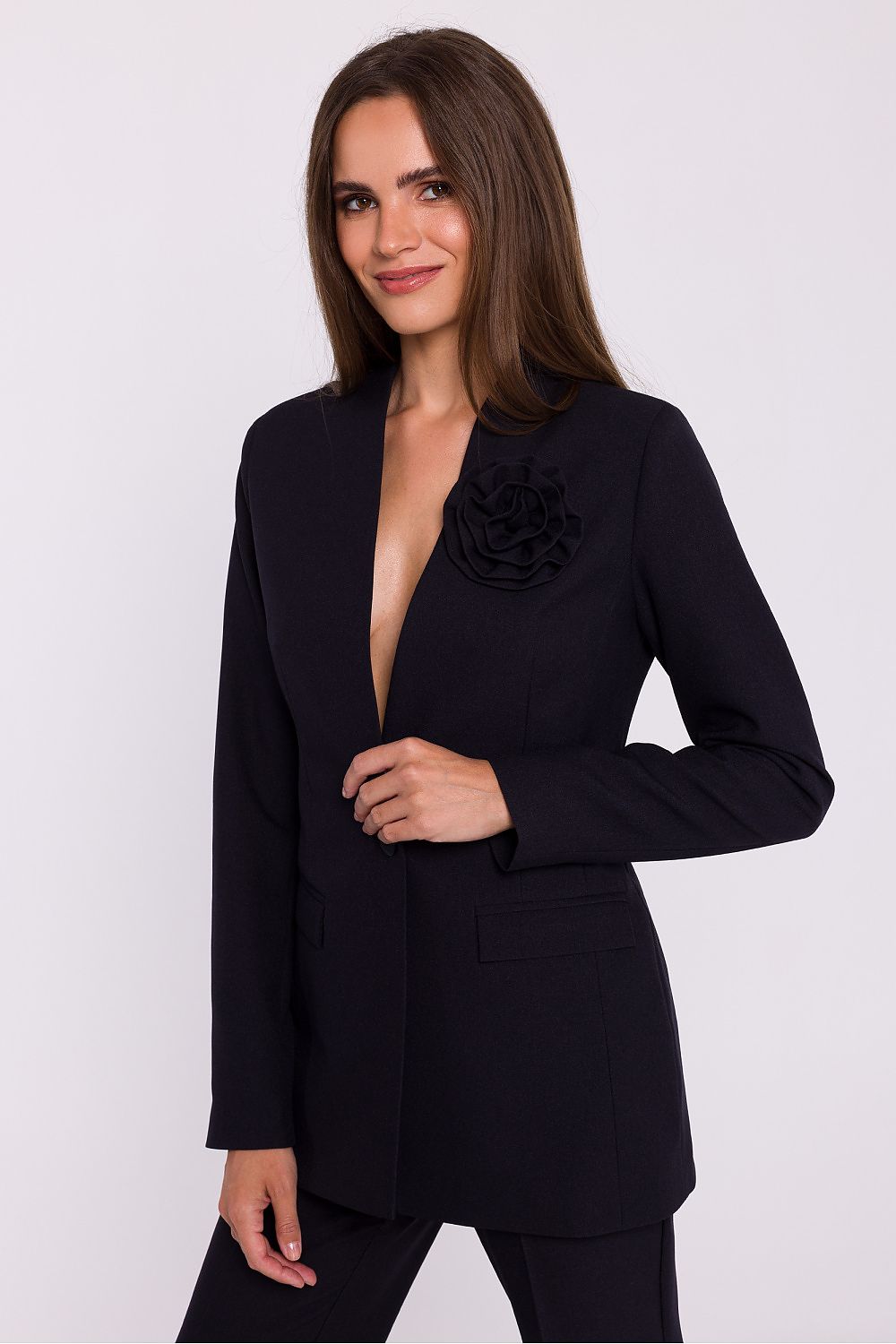 Femme portant un blazer élégant couleur noir avec fleur décorative, fabriqué en Europe, inspiré par la mode parisienne 