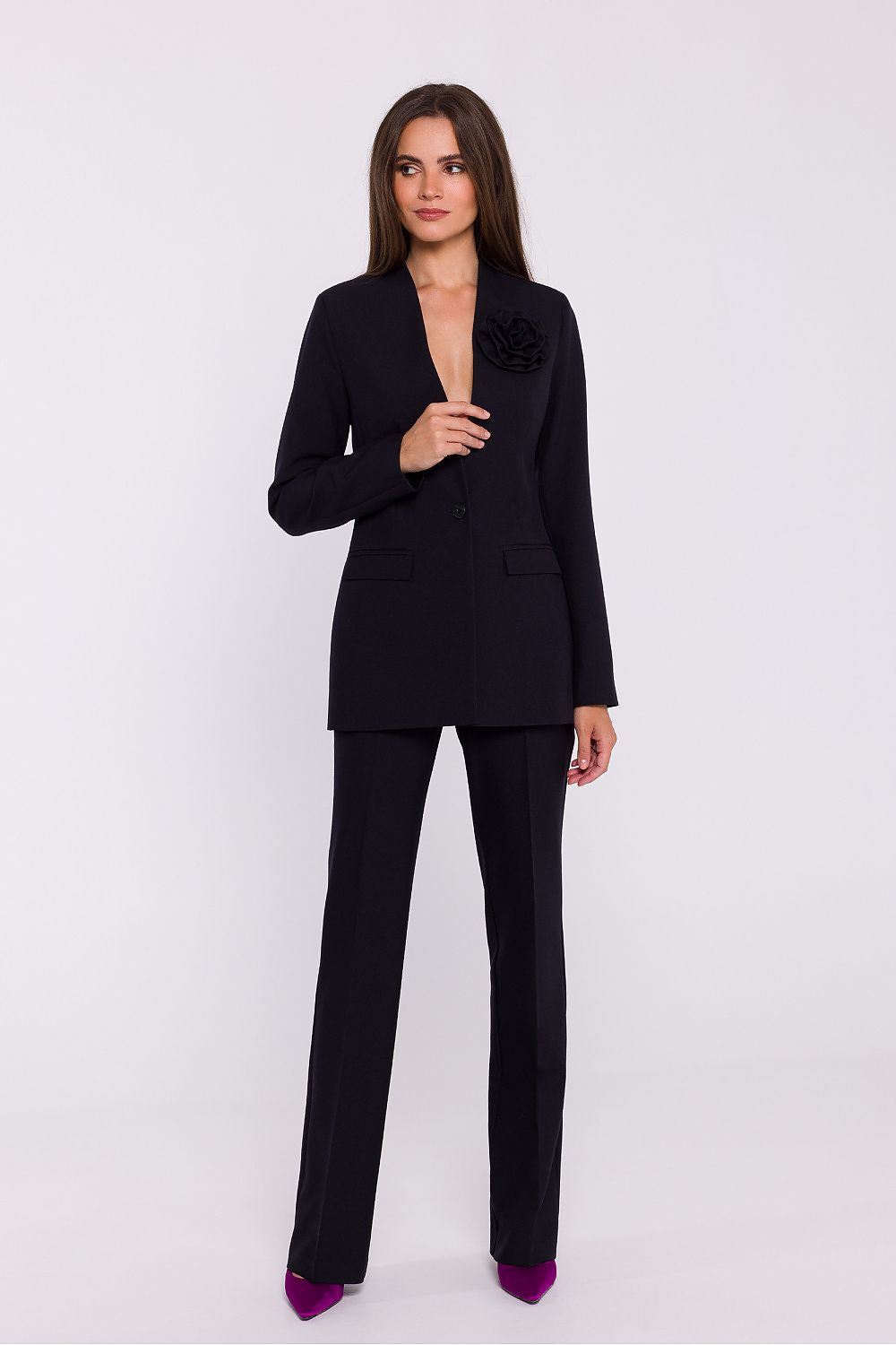 Femme portant un blazer élégant couleur noir avec fleur décorative, fabriqué en Europe, inspiré par la mode parisienne 