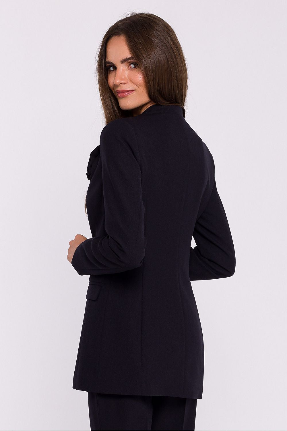 Femme portant un blazer élégant couleur noir avec fleur décorative, fabriqué en Europe, inspiré par la mode parisienne 