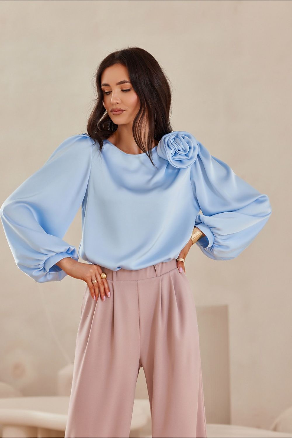 Chemise satinée bleu clair pour femme, style élégant et fluide avec manches bouffantes.