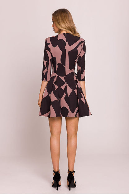 Femme portant une robe courte imprimée noire et rose avec décolleté en V, boutons décoratifs à la taille et jupe évasée plissée, conçue en Europe, mode parisienne chic et féminine