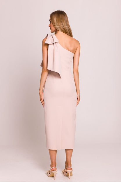 Femme portant une robe midi rose pâle à une épaule avec nœud décoratif, coupe asymétrique et fente arrière, fabriquée en Europe, mode parisienne