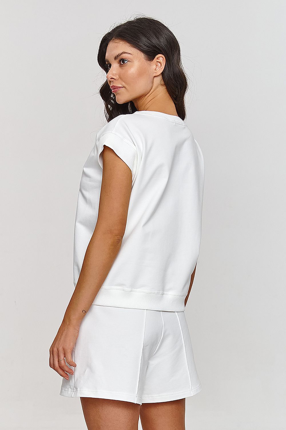 Femme portant un ensemble blanc avec t-shirt sans manches et short fluide, mode parisienne, fabriqué en Europe