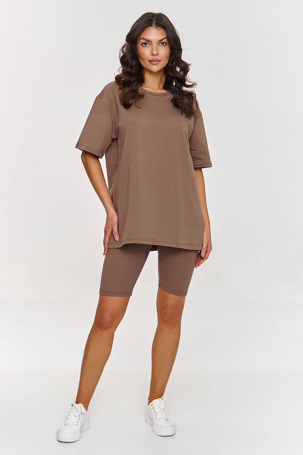 Femme portant un ensemble brun avec t-shirt oversize et short legging moulant, mode parisienne, fabriqué en Europe