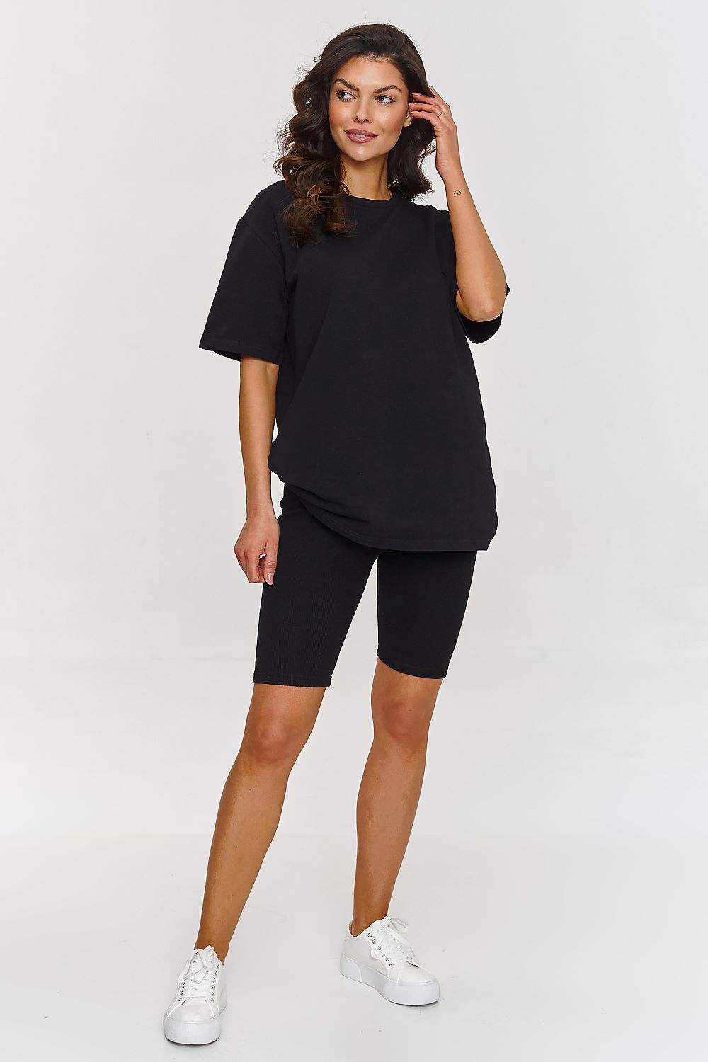 Femme portant un ensemble noir composé d’un t-shirt oversize et d’un short legging stretch, mode parisienne, fabriqué en Europe 