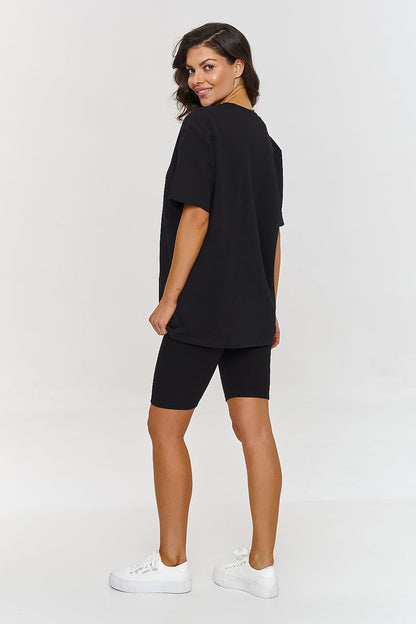 Femme portant un ensemble noir composé d’un t-shirt oversize et d’un short legging stretch, mode parisienne, fabriqué en Europe