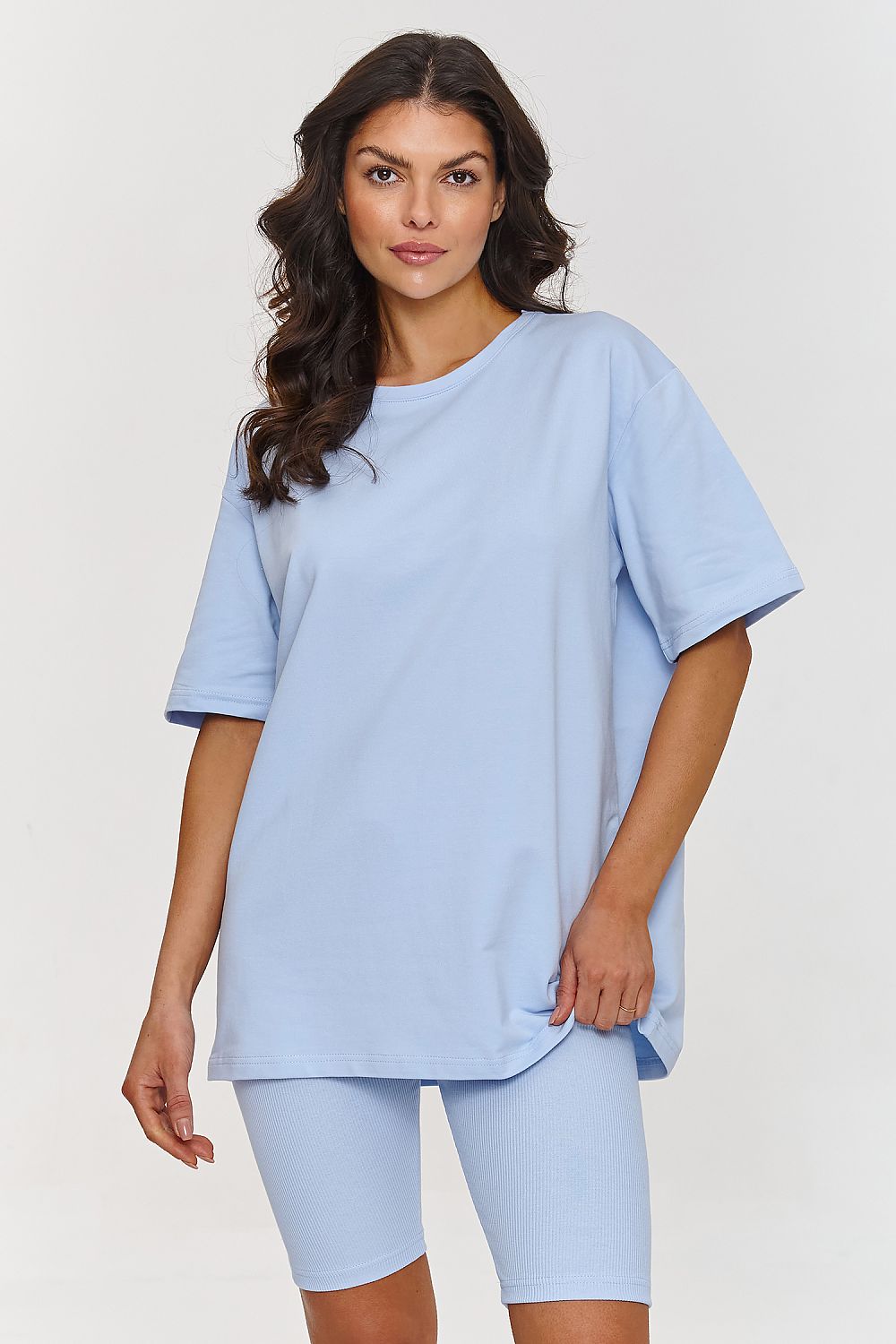 Femme portant un ensemble bleu avec haut ample et short legging ajusté, style mode parisienne, fabriqué en Europe