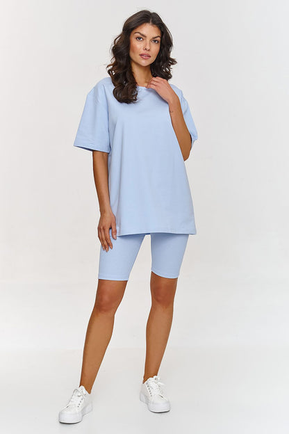Femme portant un ensemble bleu avec haut ample et short legging ajusté, style mode parisienne, fabriqué en Europe