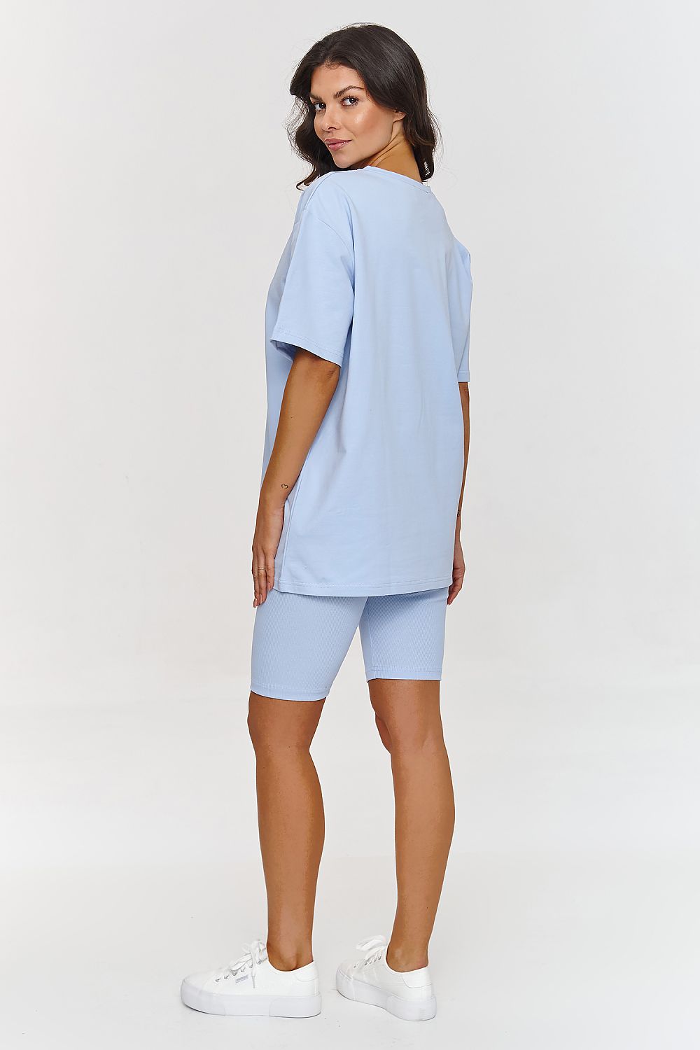 Femme portant un ensemble bleu avec haut ample et short legging ajusté, style mode parisienne, fabriqué en Europe 