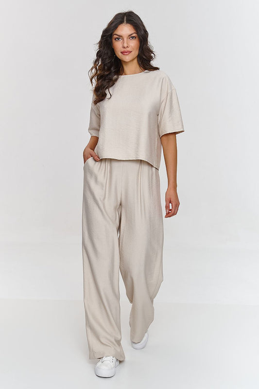 Femme portant un ensemble beige décontracté avec haut à manches courtes et pantalon large, fabriqué en Europe, mode parisienne