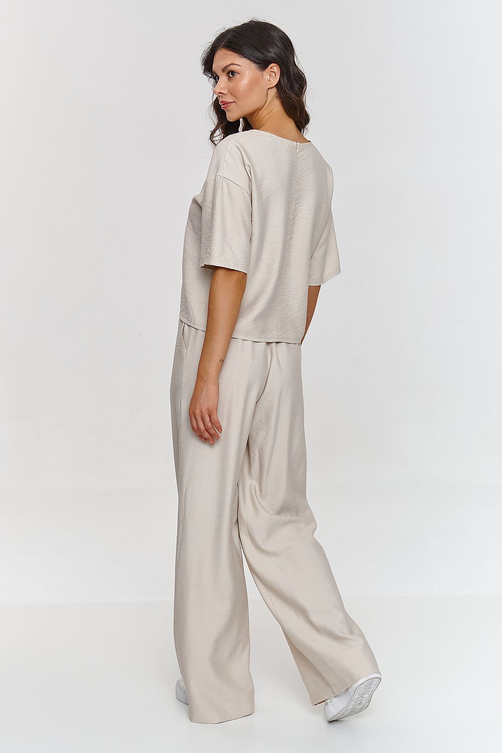 Femme portant un ensemble beige décontracté avec haut à manches courtes et pantalon large, fabriqué en Europe, mode parisienne