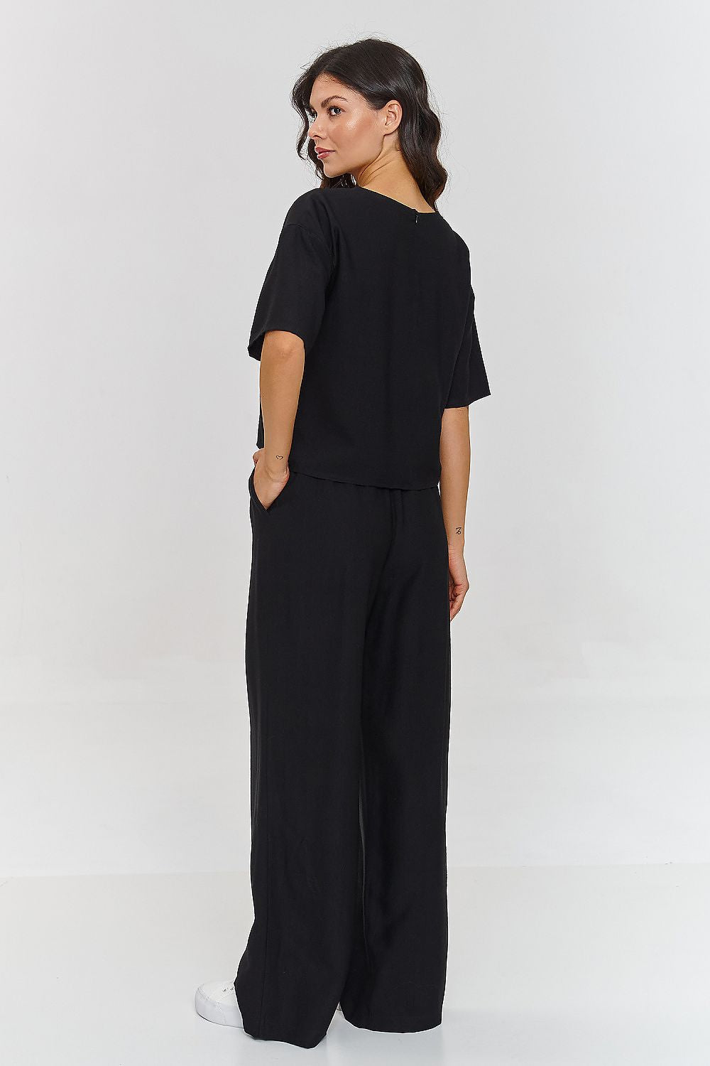 Femme portant un ensemble noir décontracté avec haut à manches courtes et pantalon large, fabriqué en Europe, mode parisienne

