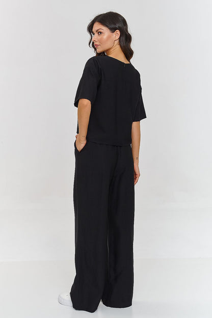 Femme portant un ensemble noir décontracté avec haut à manches courtes et pantalon large, fabriqué en Europe, mode parisienne

