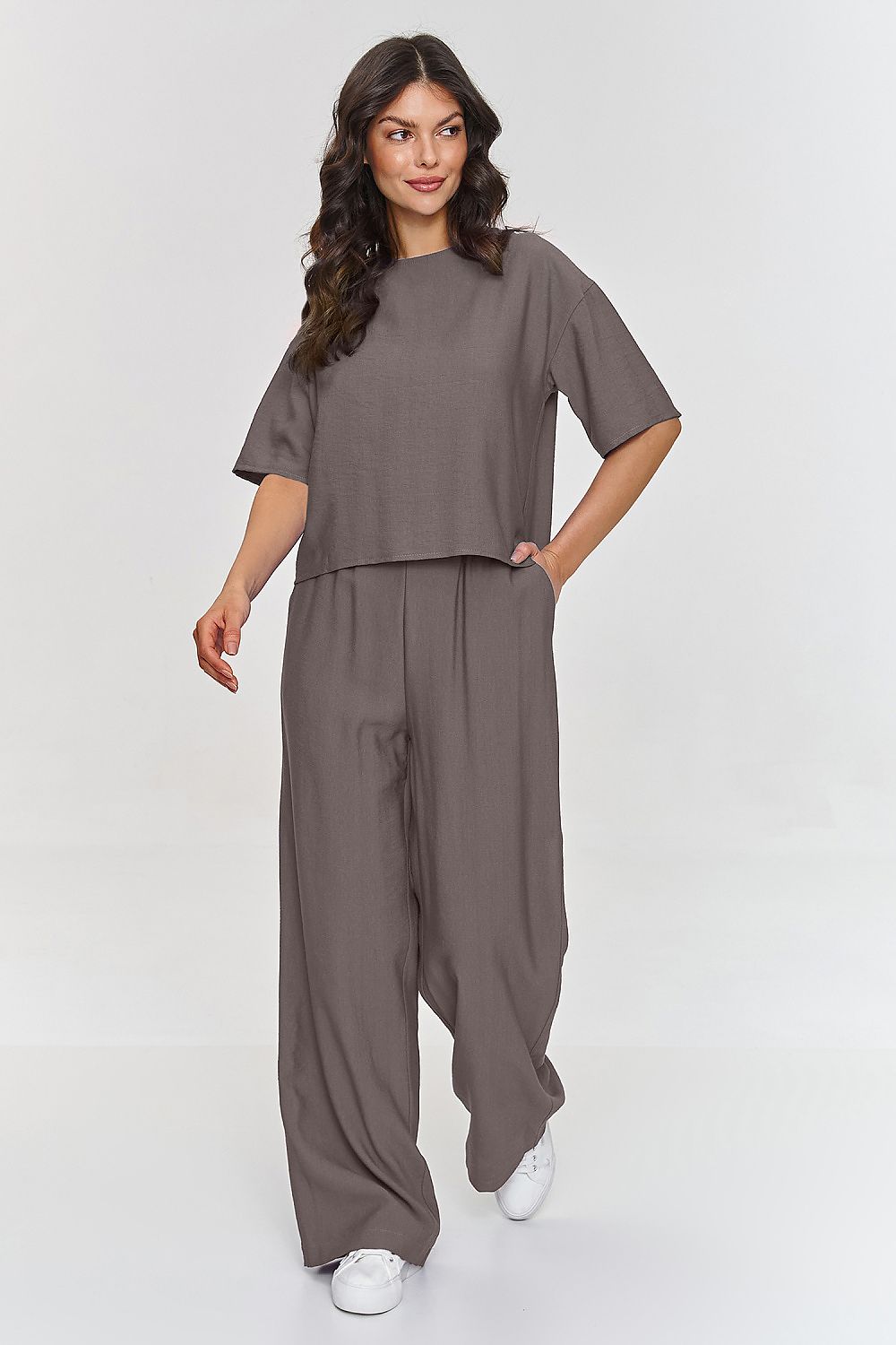 Femme portant un ensemble brun décontracté avec haut à manches courtes et pantalon large, fabriqué en Europe, mode parisienne
