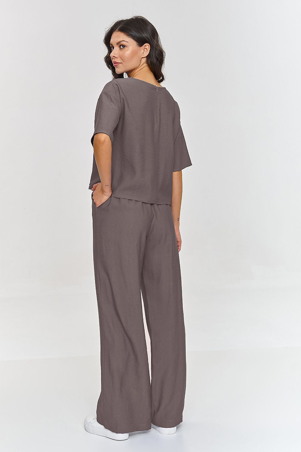 Femme portant un ensemble brun décontracté avec haut à manches courtes et pantalon large, fabriqué en Europe, mode parisienne 