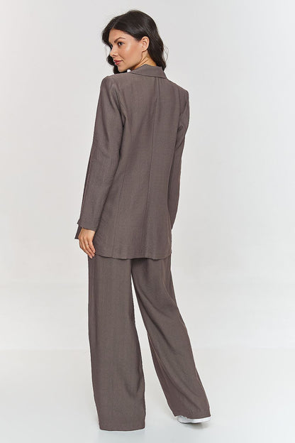 Femme portant un ensemble brun élégant avec blazer ceinturé et pantalon large, fabriqué en Europe, mode parisienne