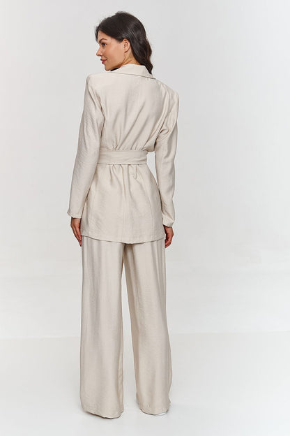 Femme portant un ensemble beige élégant avec blazer ceinturé et pantalon large, fabriqué en Europe, mode parisienne