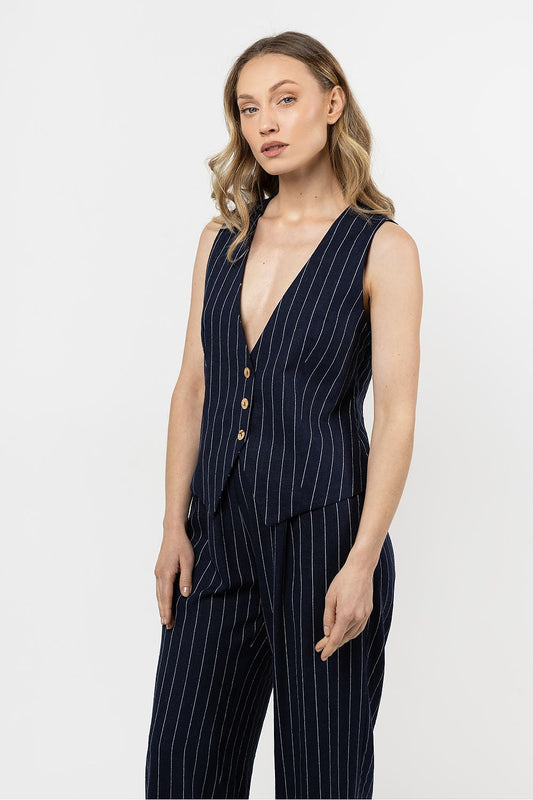 Femme portant un gilet sans manches en lin bleu marine à rayures fines, coupe courte élégante.