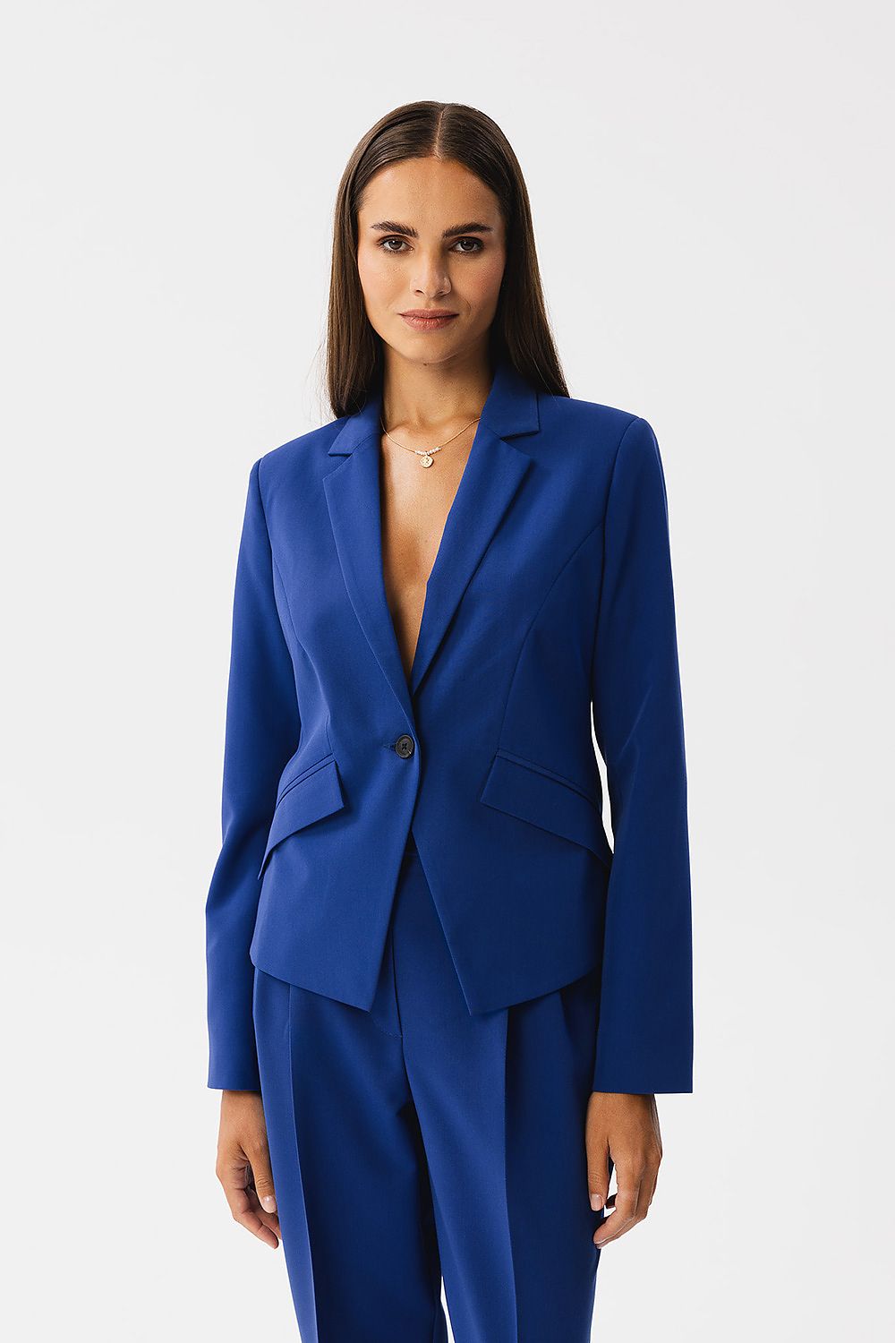 Veste tailleur bleu royal de VidenaParis portée avec pantalon assorti, coupe élégante et asymétrique.