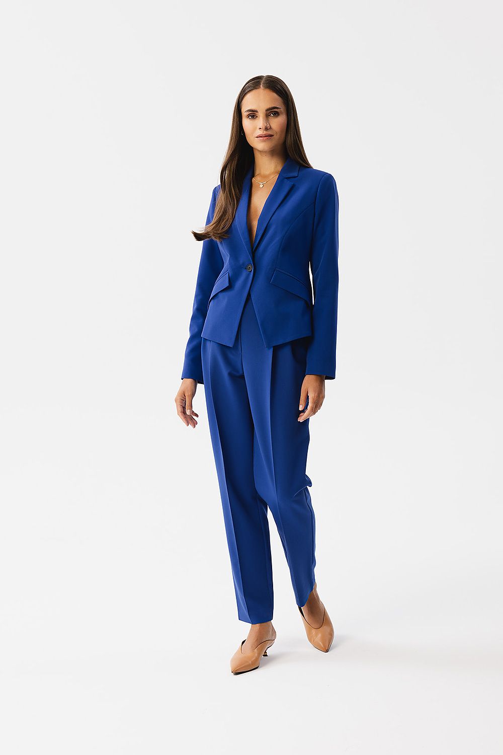 Veste tailleur bleu royal de VidenaParis portée avec pantalon assorti, coupe élégante et asymétrique.